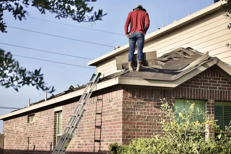 Professional roofer working on a residential roof in Central College